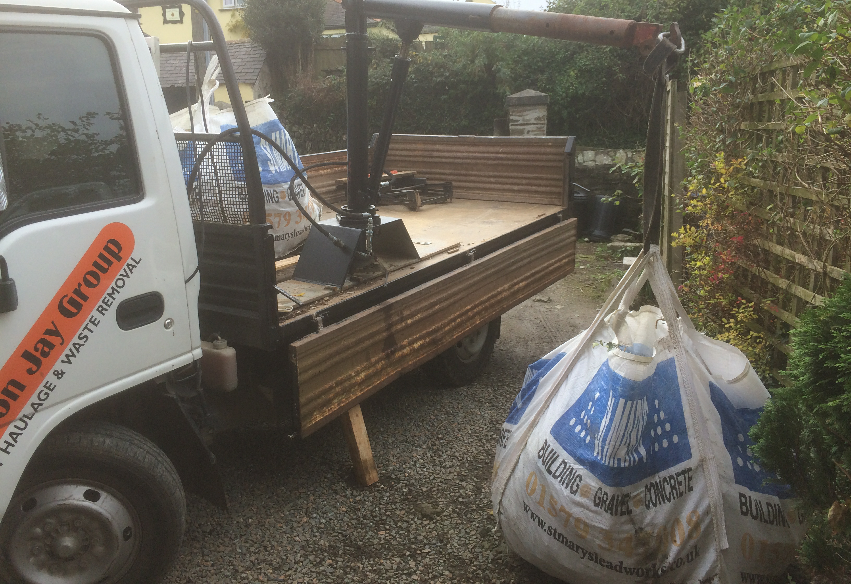 An image showing a pickup collecting a dumpy bag